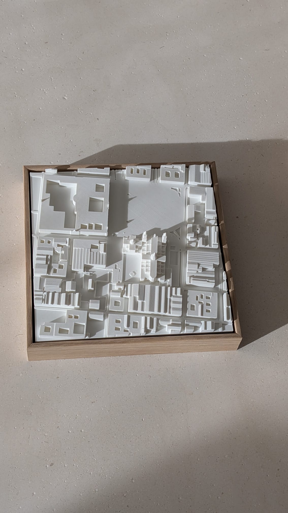 3D city map wall art in a wooden frame with detailed white architectural buildings