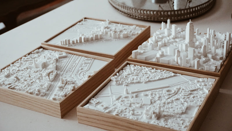 Set of four 3D city map wall art pieces with intricate urban details and wooden frames